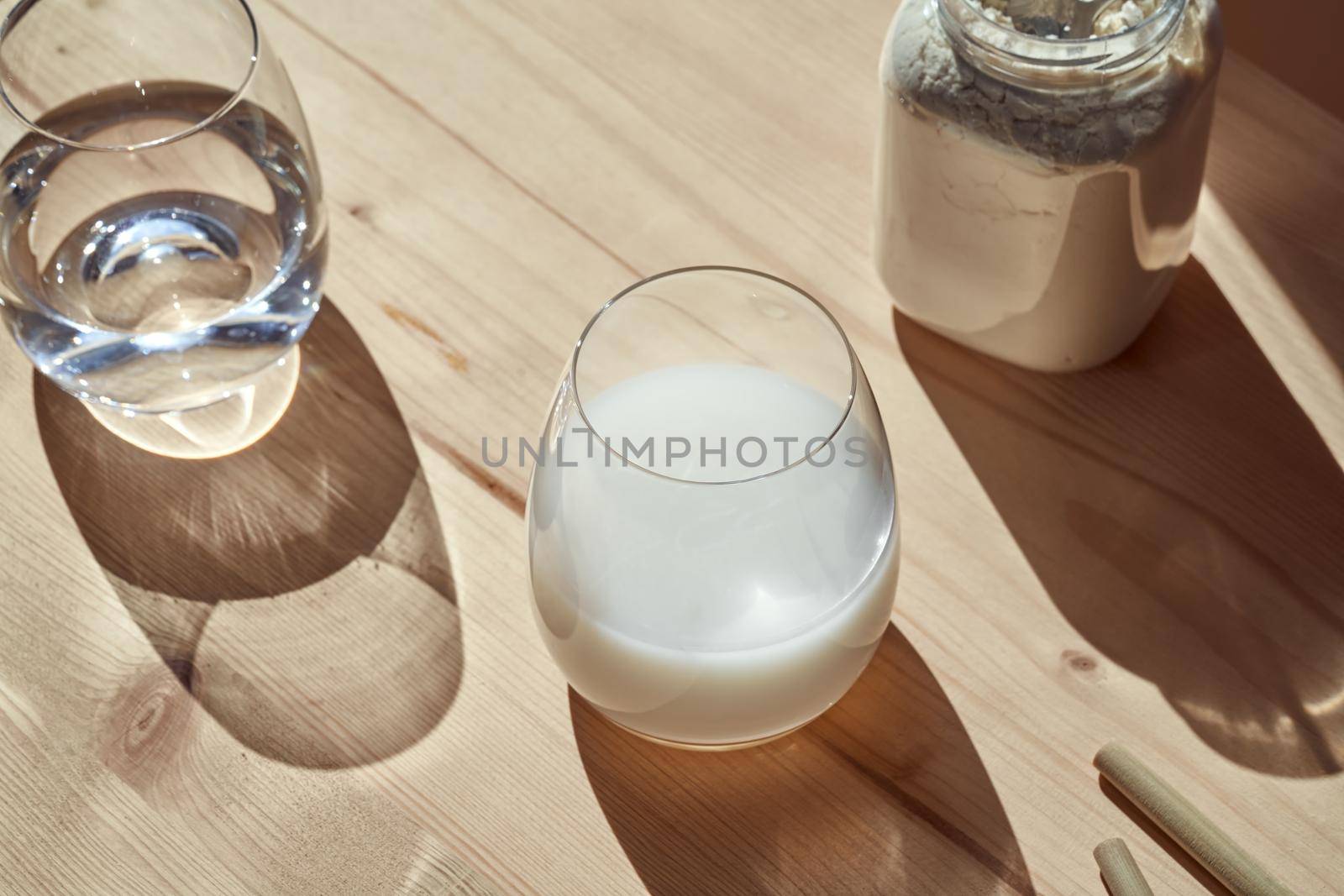 Whey protein drink and powder on a table under sunlight