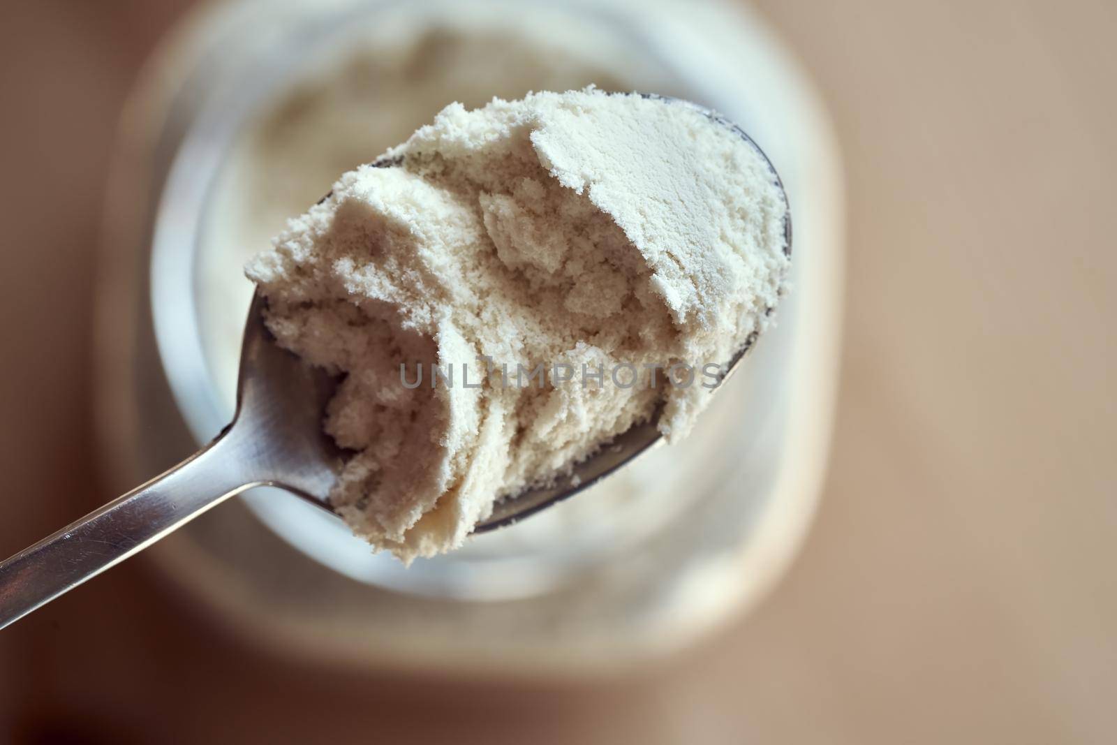 Whey protein powder on a spoon, top view