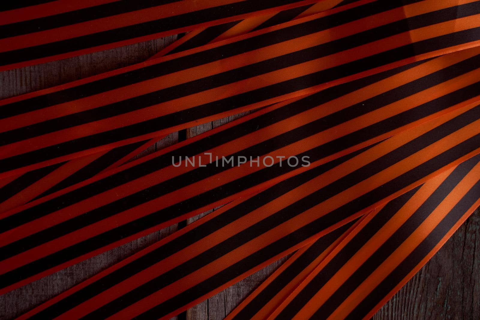 Black orange St. George ribbons on a wooden background by Xelar