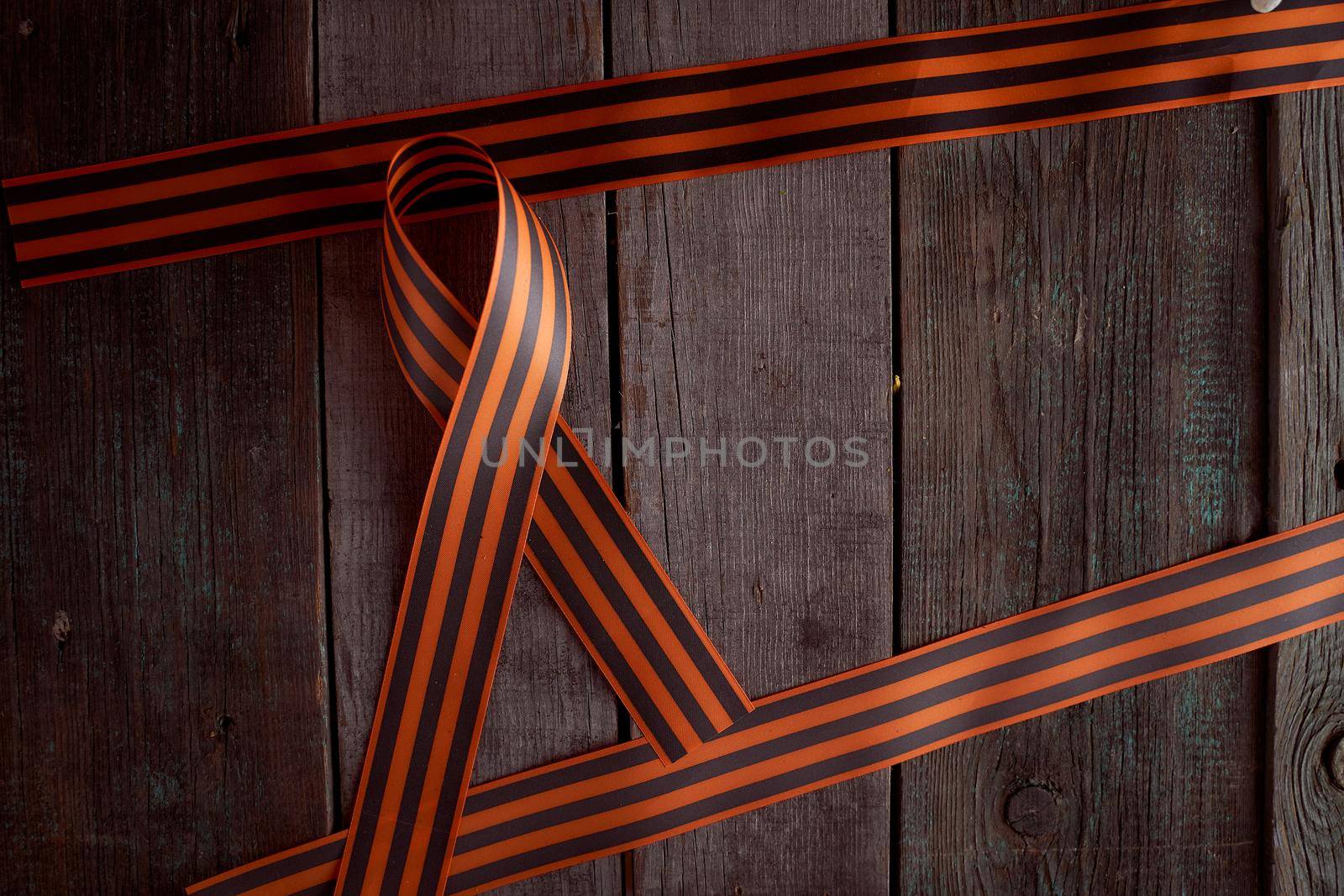 Folded St. George ribbon on a wooden background by Xelar