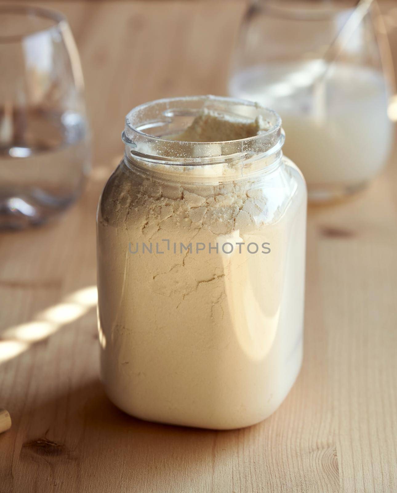 Whey protein powder in a plastic jar on a table