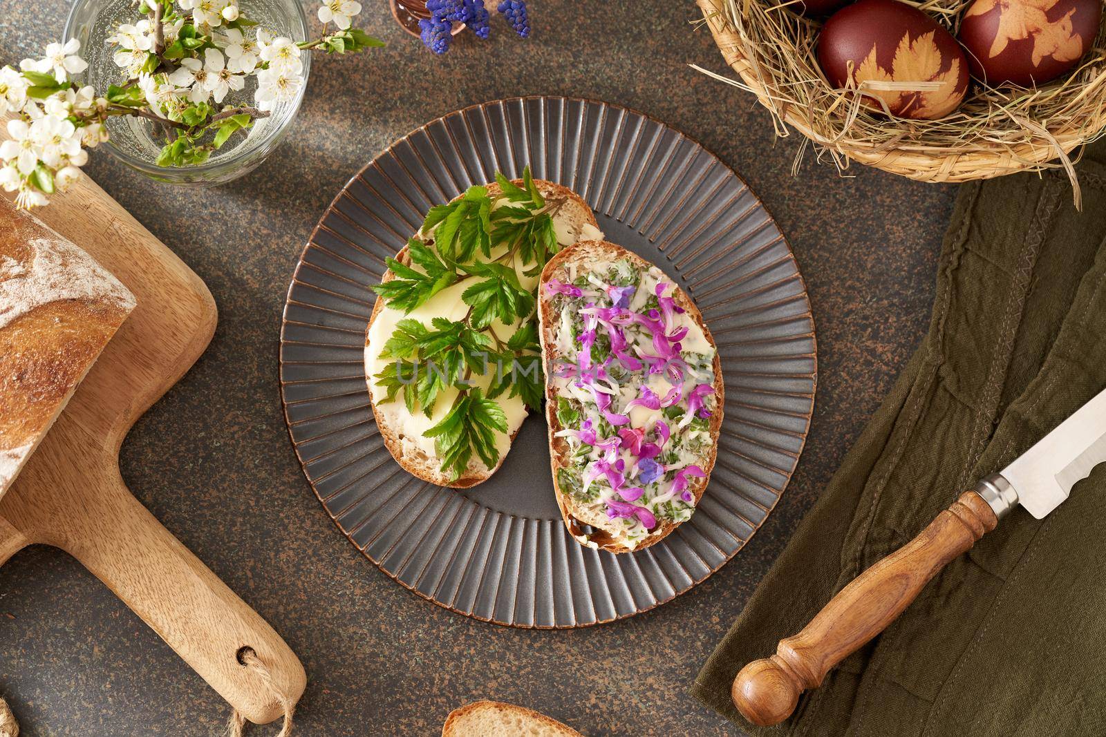 Sourdough bread with butter and wild edible spring plants - goutweed leaves, purple dead-nettle and lungwort by madeleine_steinbach