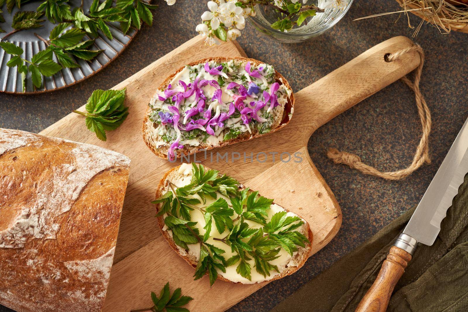 Sourdough bread with wild edible spring plants - young goutweed leaves, purple dead-nettle and lungwort flowers by madeleine_steinbach