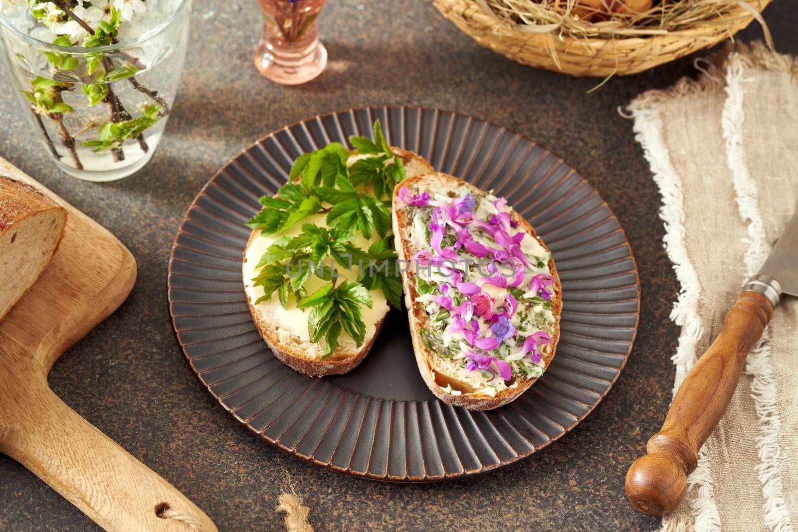 Slices of sourdough bread with butter and wild edible spring plants - goutweed, purple dead-nettle and lungwort by madeleine_steinbach