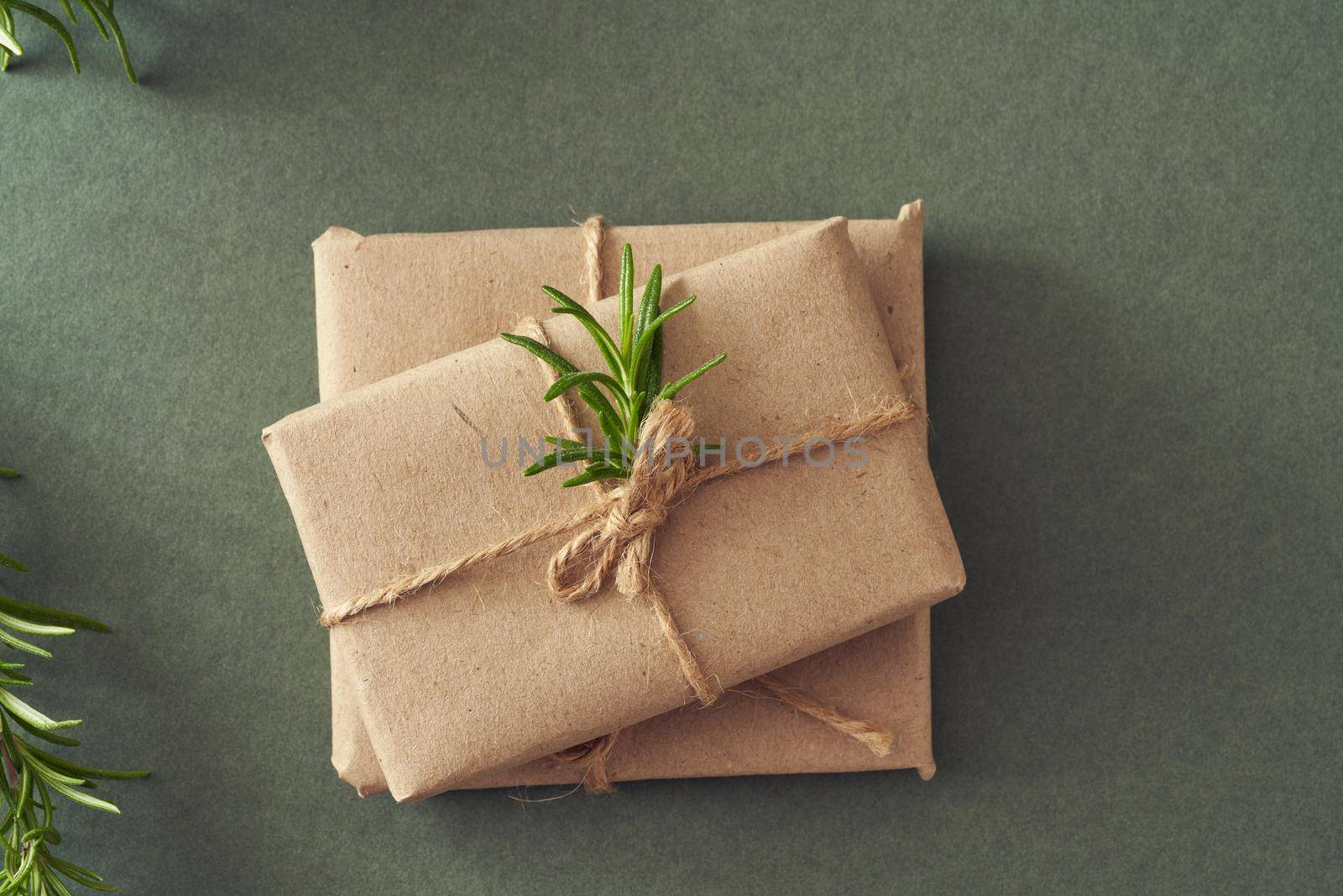 Christmas presents wrapped in ecological recycled paper on green paper background by madeleine_steinbach