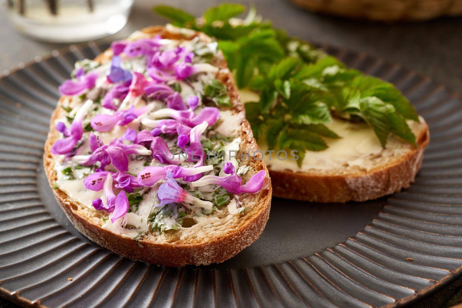 Slices of sourdough bread with wild edible spring plants - ground elder leaves, lungwort and purple dead-nettle by madeleine_steinbach