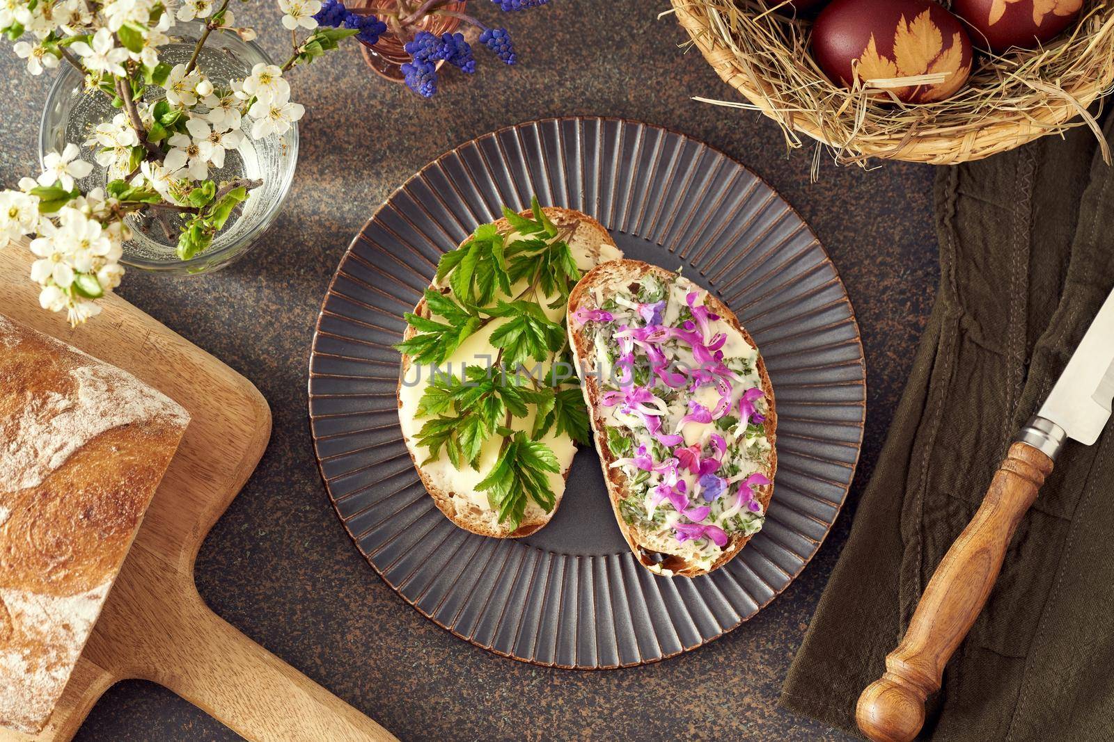 Slices of Sourdough bread with ground elder leaves, lungwort and purple dead-nettle flowers by madeleine_steinbach