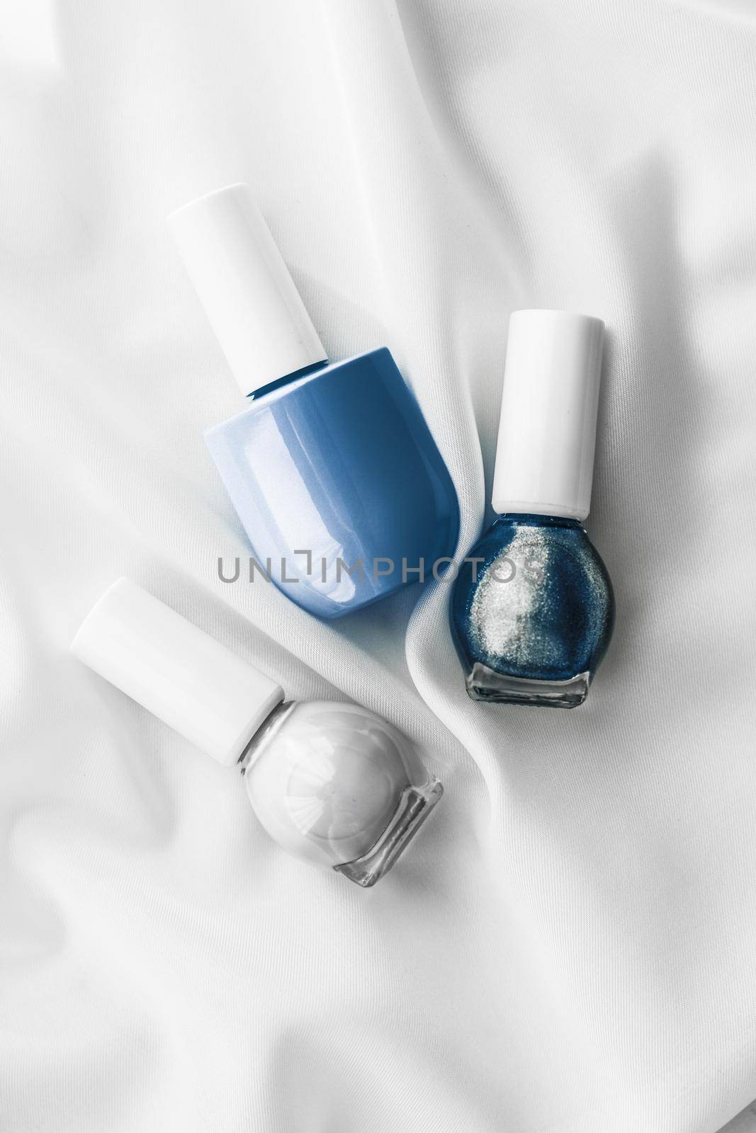 Cosmetic branding, salon and glamour concept - Nail polish bottles on silk background, french manicure products and nailpolish make-up cosmetics for luxury beauty brand and holiday flatlay art design