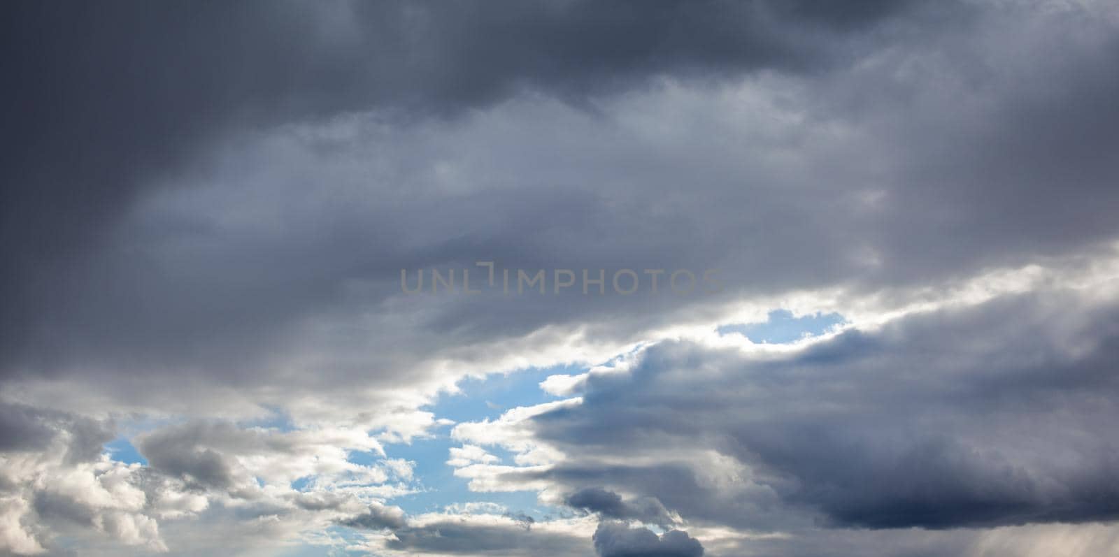 Dramatic sky with grey clouds over the city before the storm.  by AnatoliiFoto