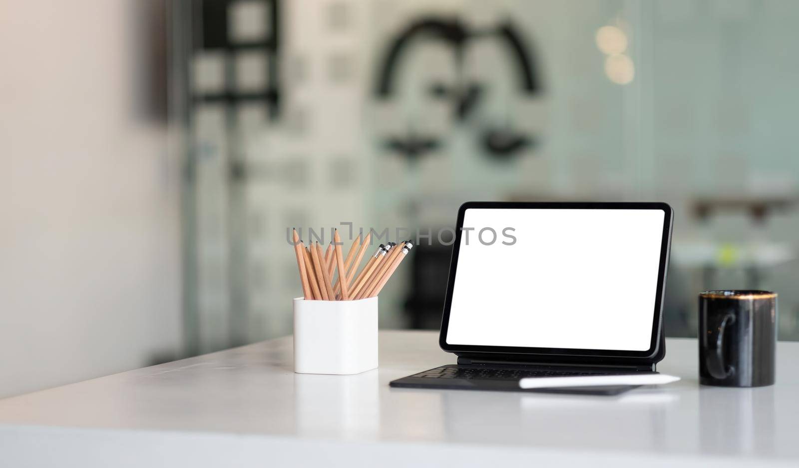 Mock up digital tablet with blank white screen on workplace at office