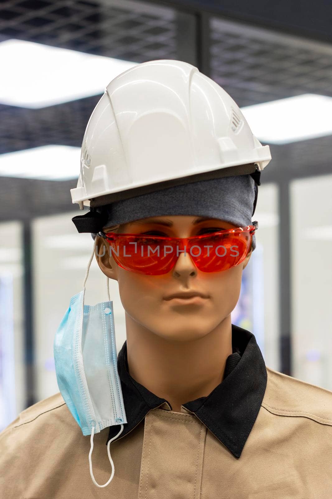 Mannequin woman in uniform headphones, cap and glasses, with medical mask hanging on the ear. Surgut, Russia - 16 April 2021 by Essffes