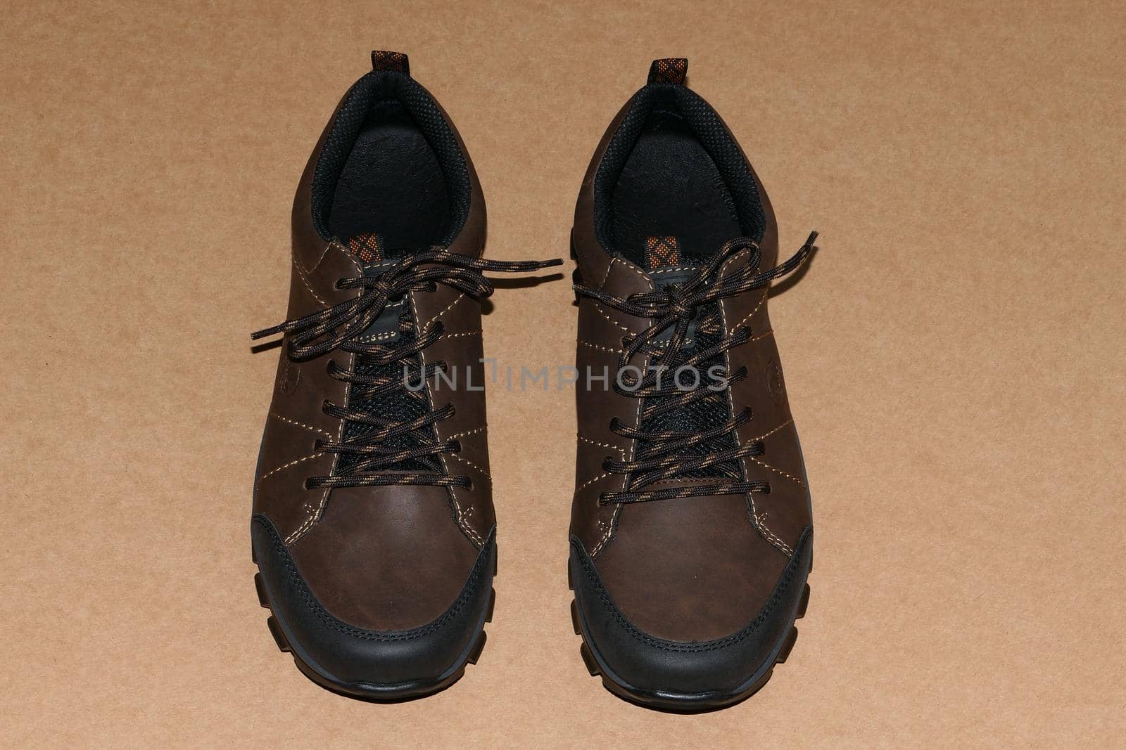 Shoes, men's brown shoes or new sneakers on a brown background. by Olga26