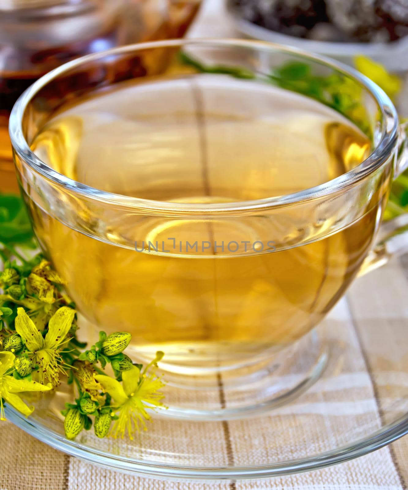 Tea in a glass cup and teapot, candy, fresh flowers tutsanon the linen tablecloth background