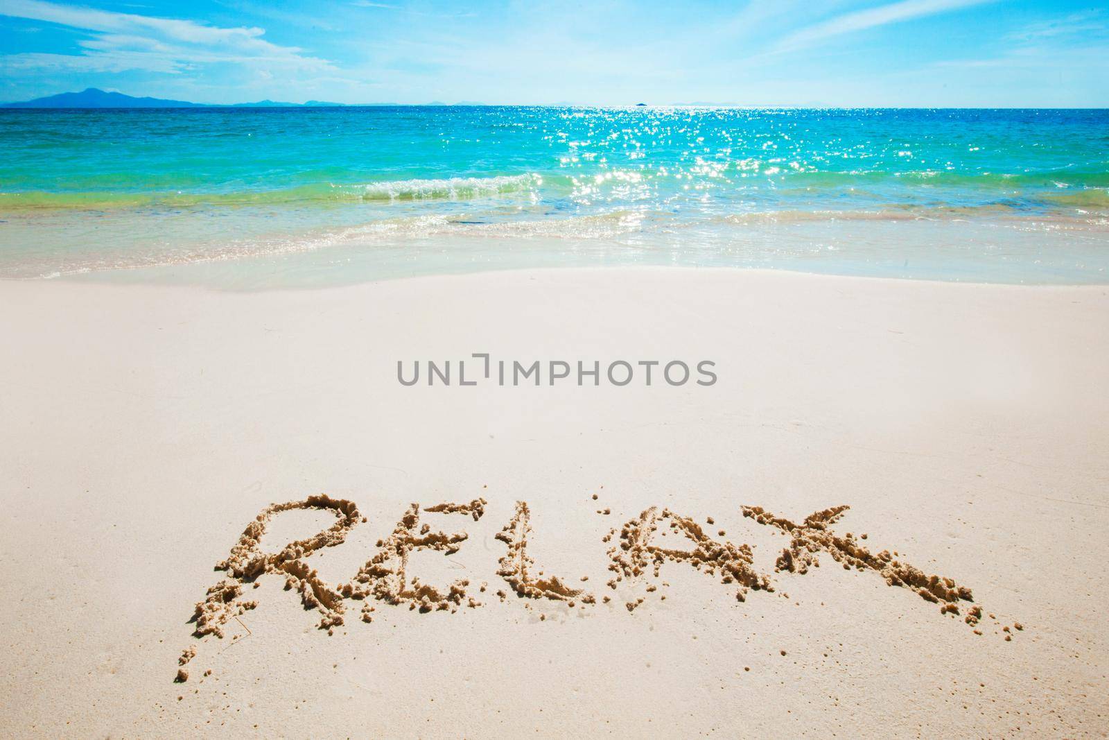 Realax word writing on tropical sea beach