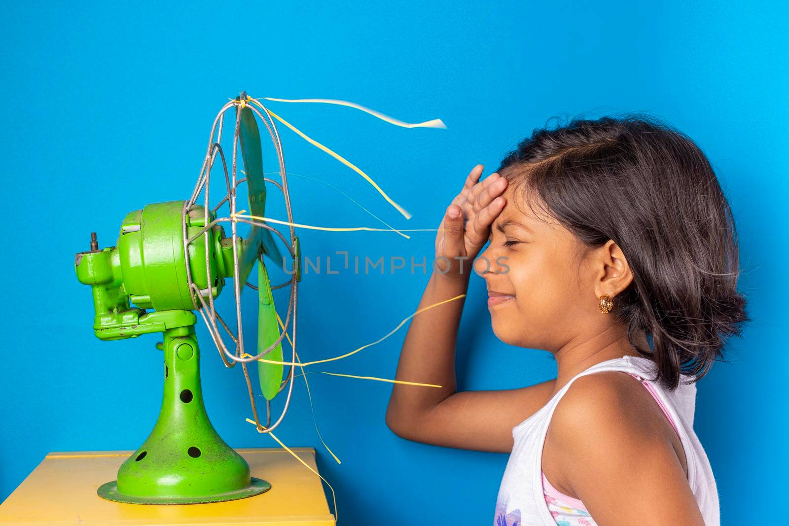 Beautiful latin girl, is cooling off the heat with an old green fan by eagg13