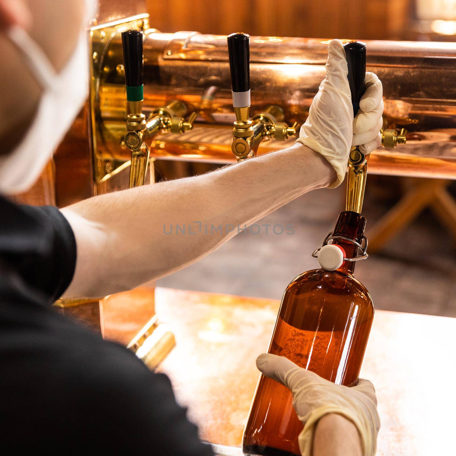 Man pouring, filling beer bottle by ferhad