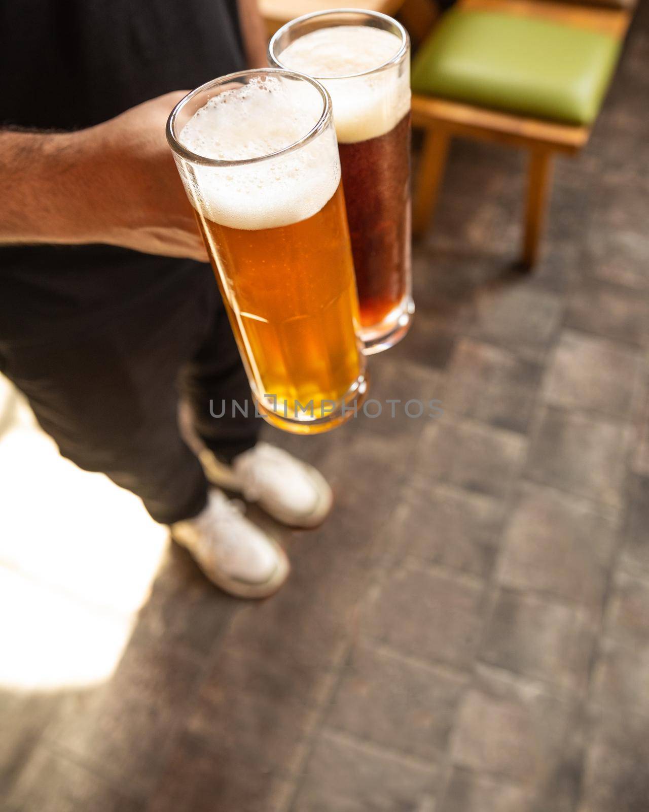 Man holding white and black beer side by side