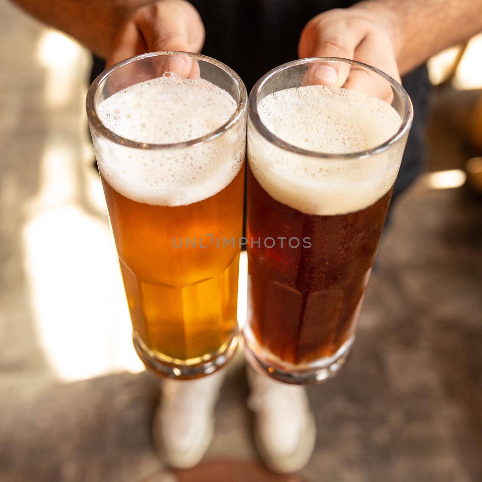 Man holding white and black beer side by side