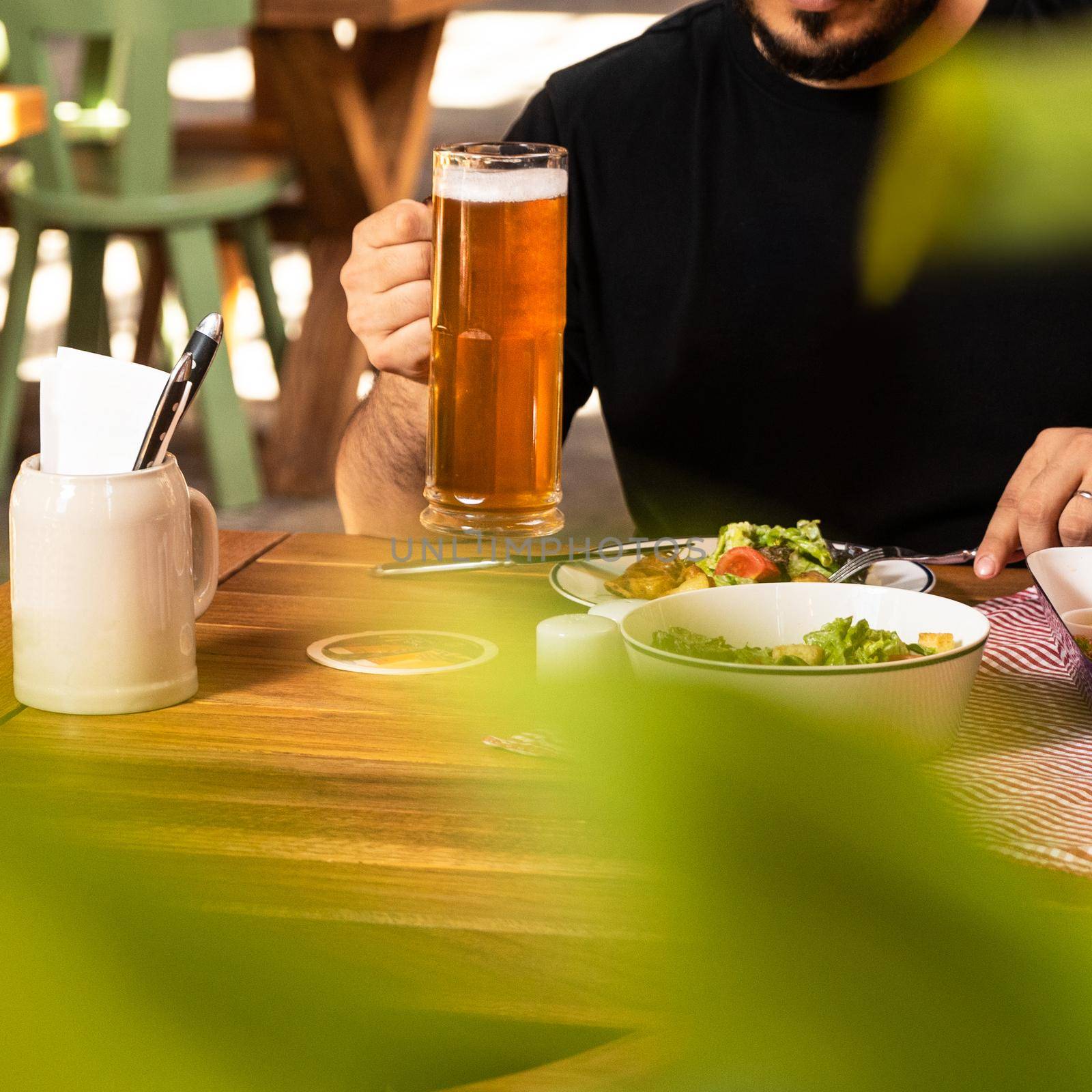 Man drinking beer with salad