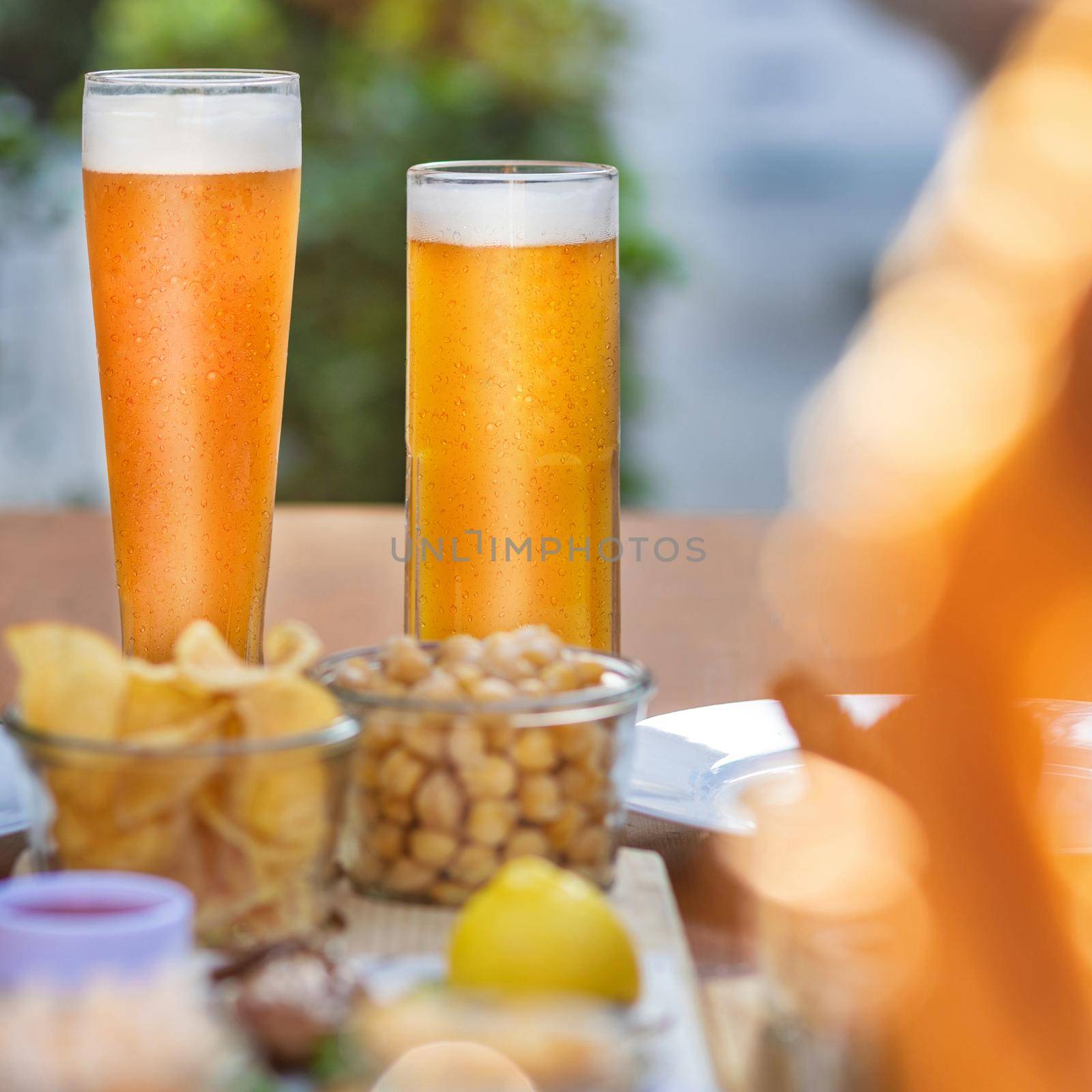 Beer mugs, glasses with snacks on the table