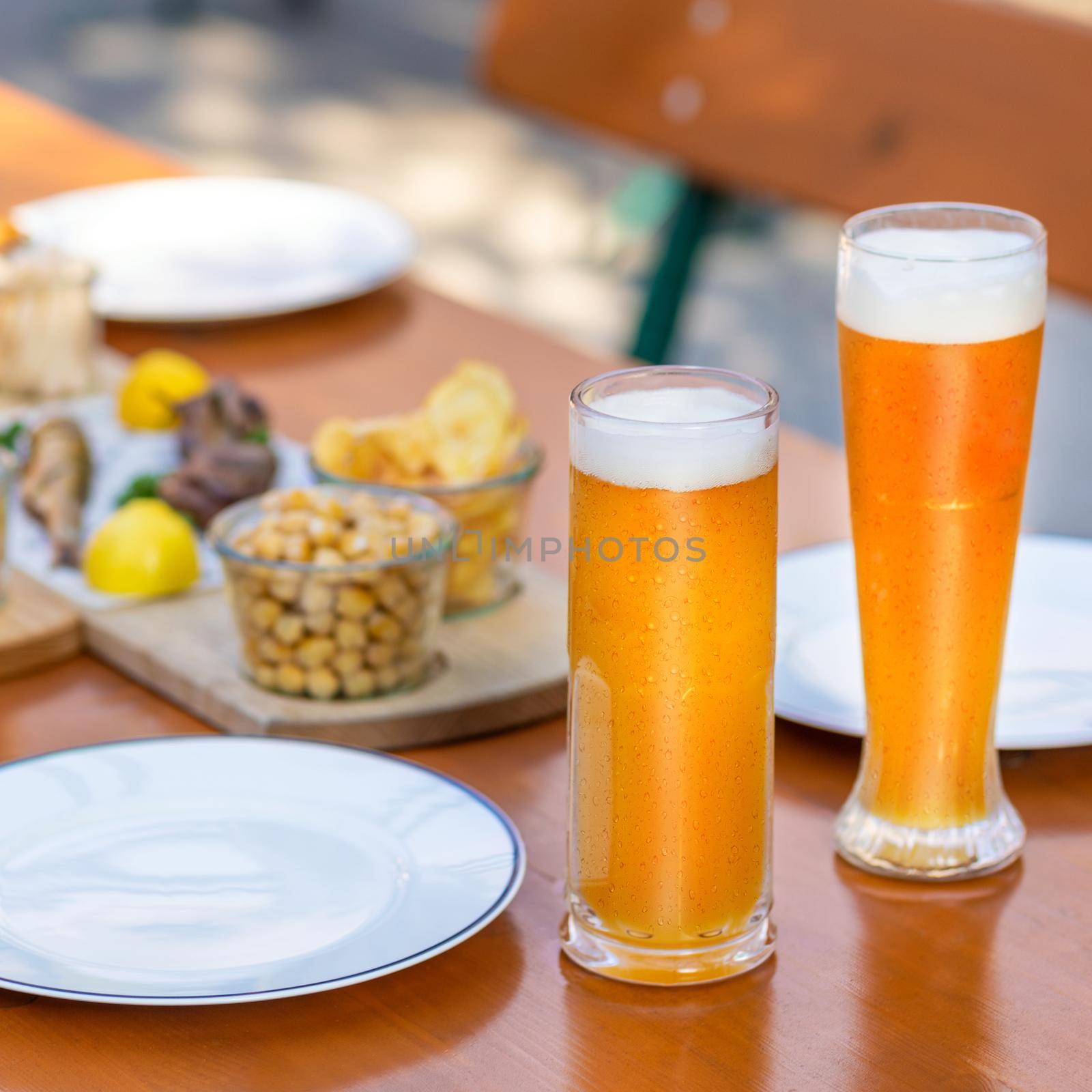 Beer mugs, glasses with snacks on the table