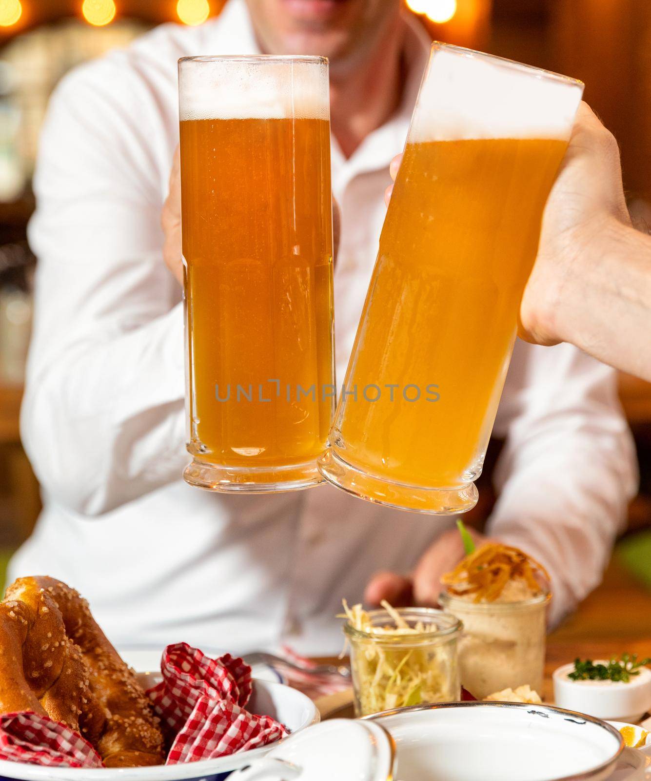 Clinking beer mugs close up, snacks on the table by ferhad