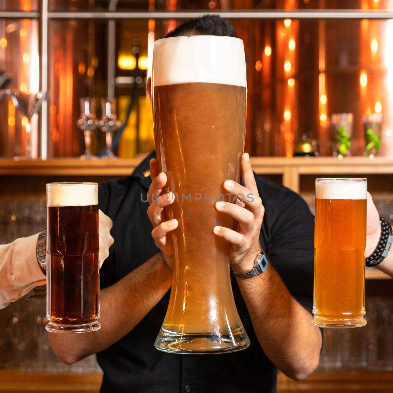 Man holding 3 liter huge beer glass, mug with black, dark beer glasses side by side by ferhad