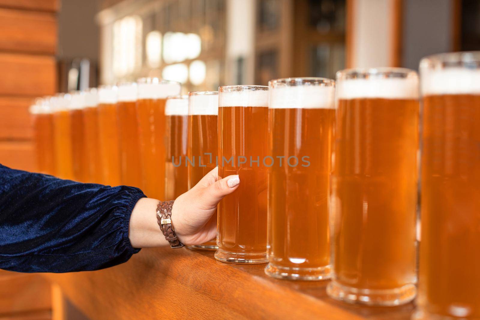 Woman taking on beer glass from a lot of choices by ferhad