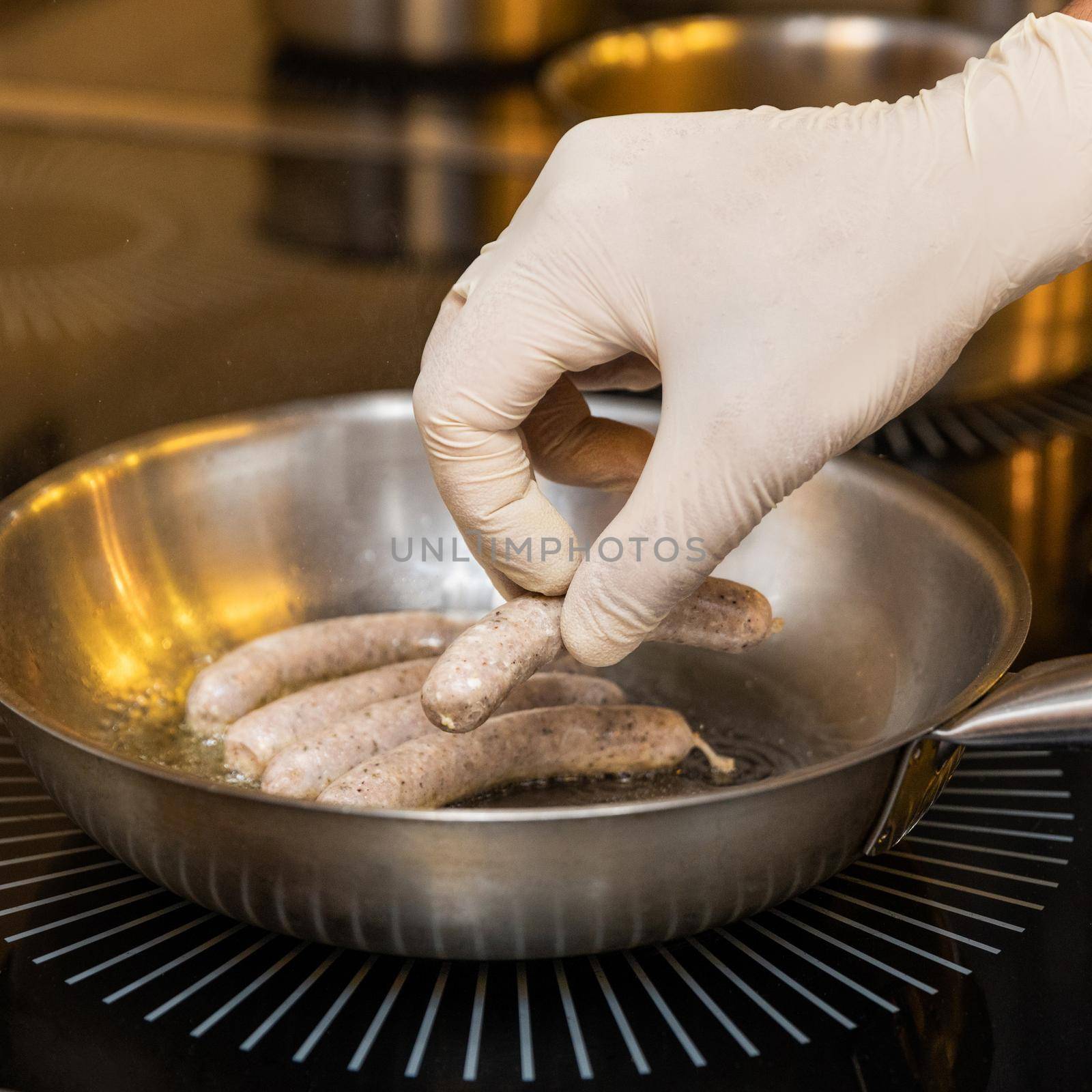 Chef cooking white German sausages