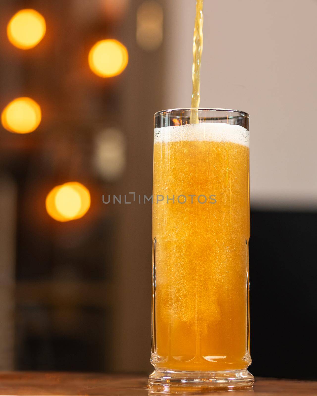 Beer pouring, filling to the mug, glass with bokeh background