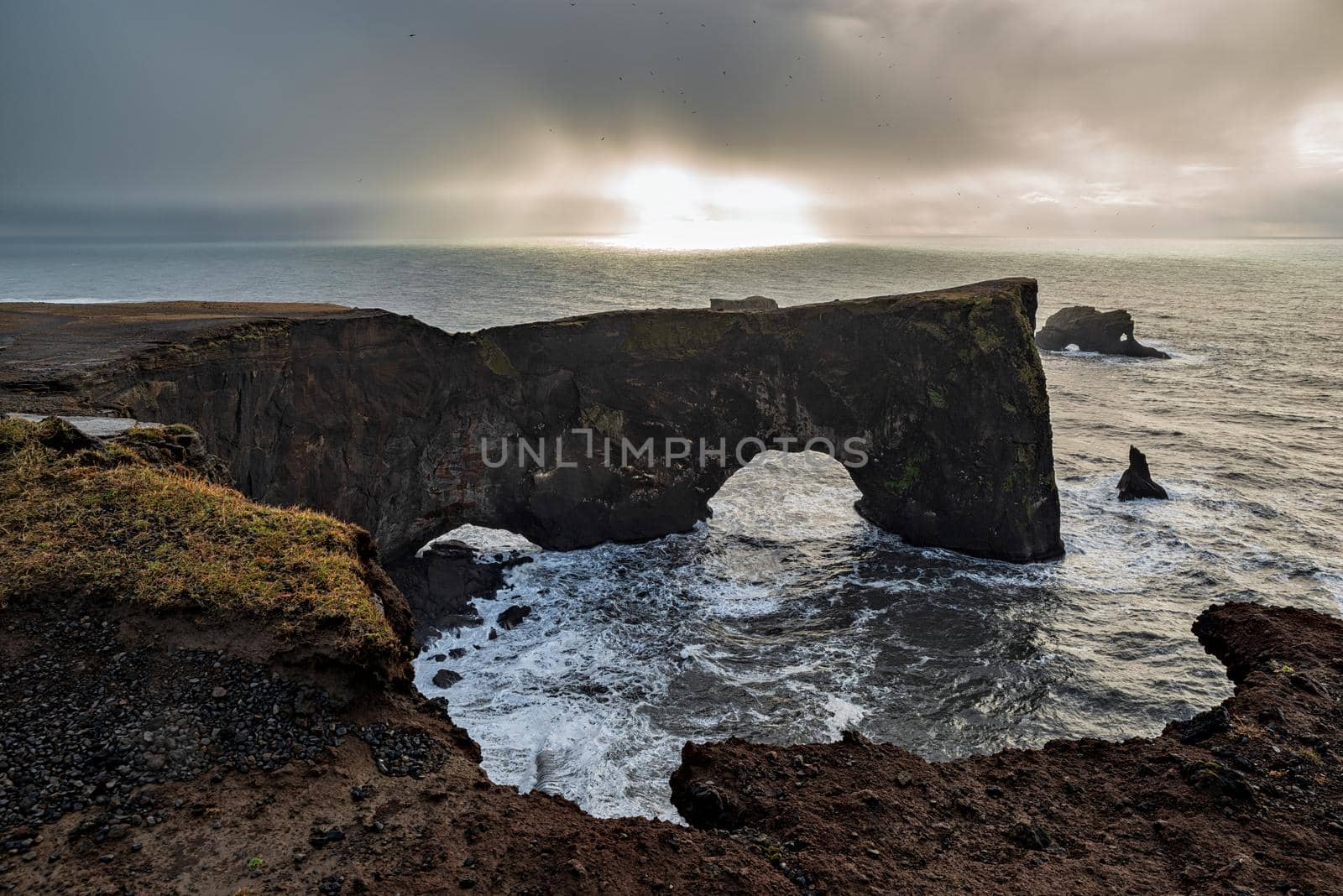 Natural arch of Dyrholaey Peninsula in South Iceland in a cloudy day