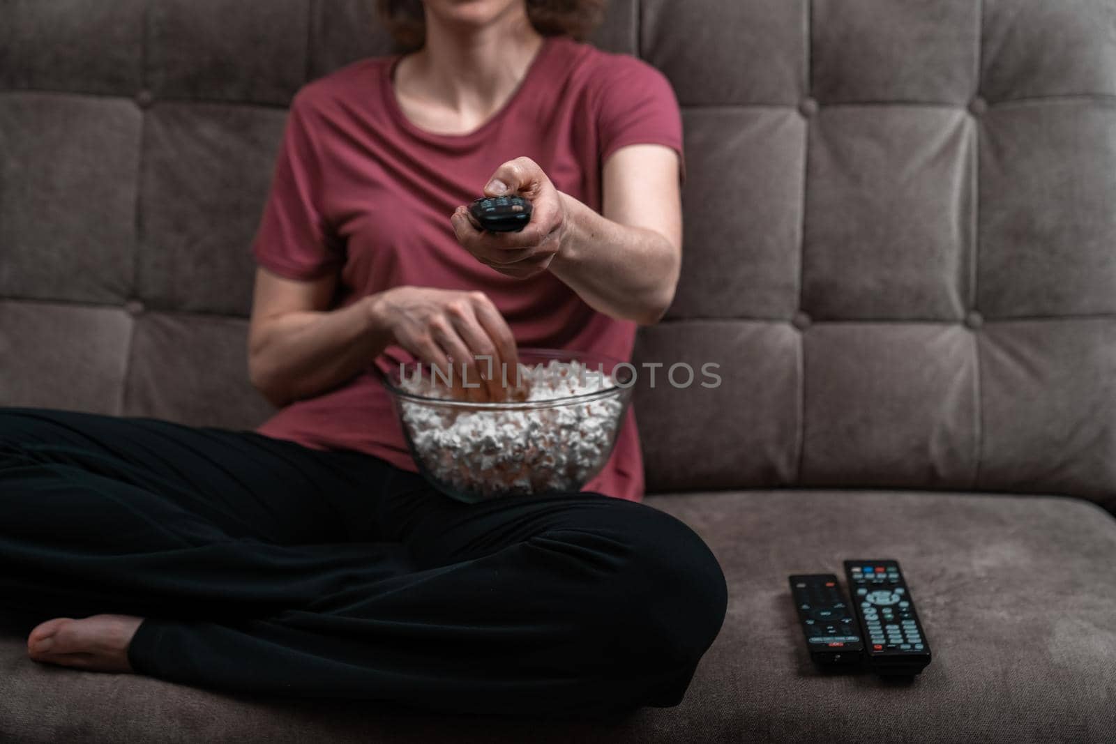 woman with popcorn watching television.