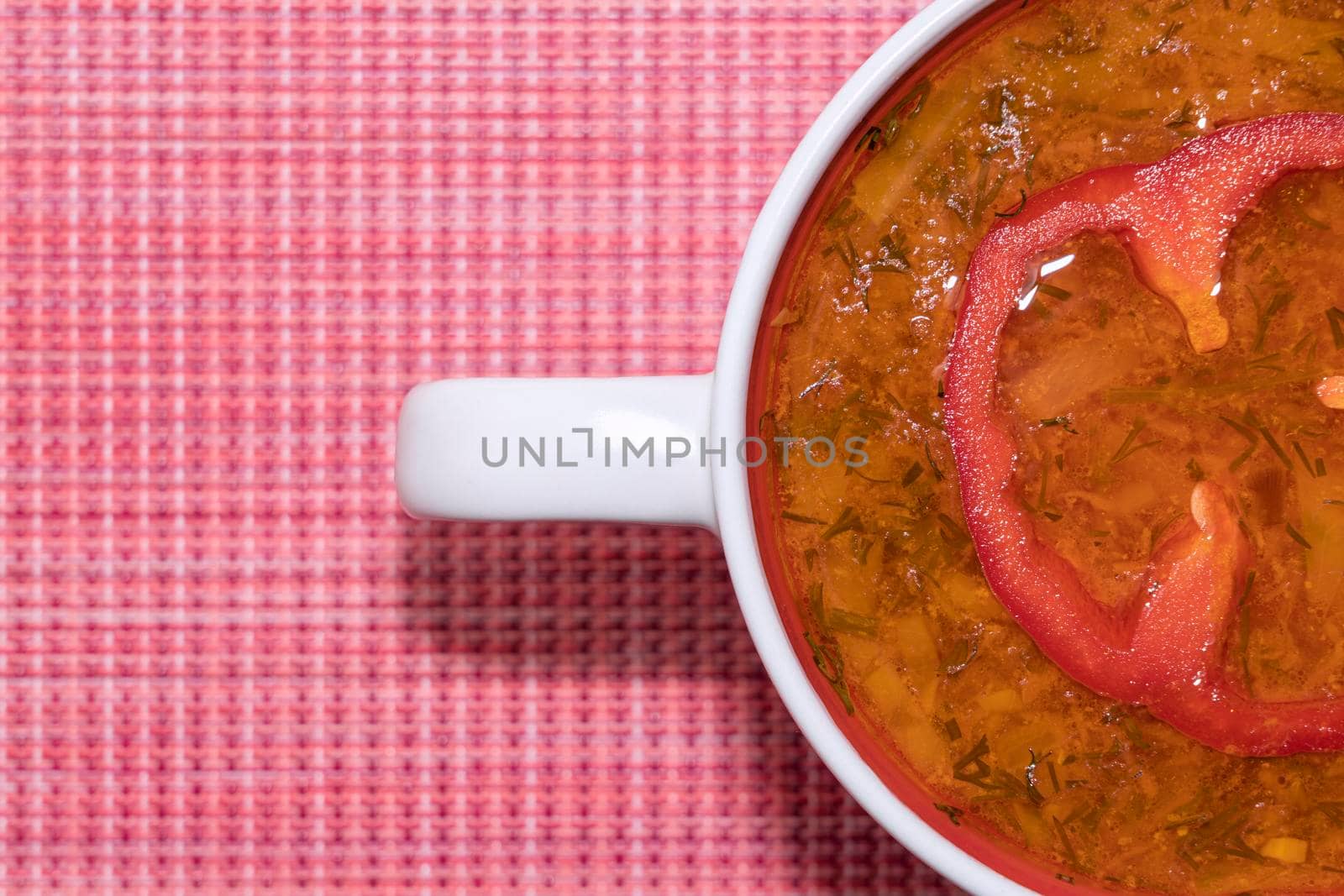 tomato soup in a mug on a red background top view. High quality photo