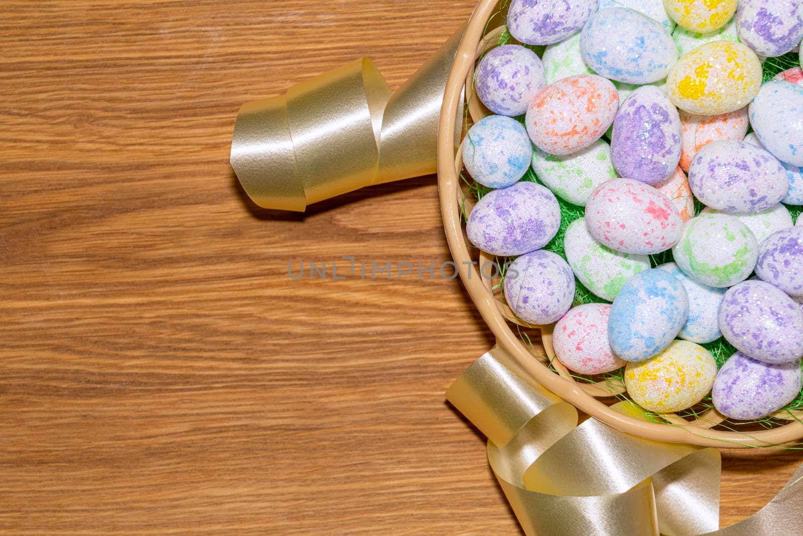 easter colorful eggs in a nest close up on a wooden background. High quality photo