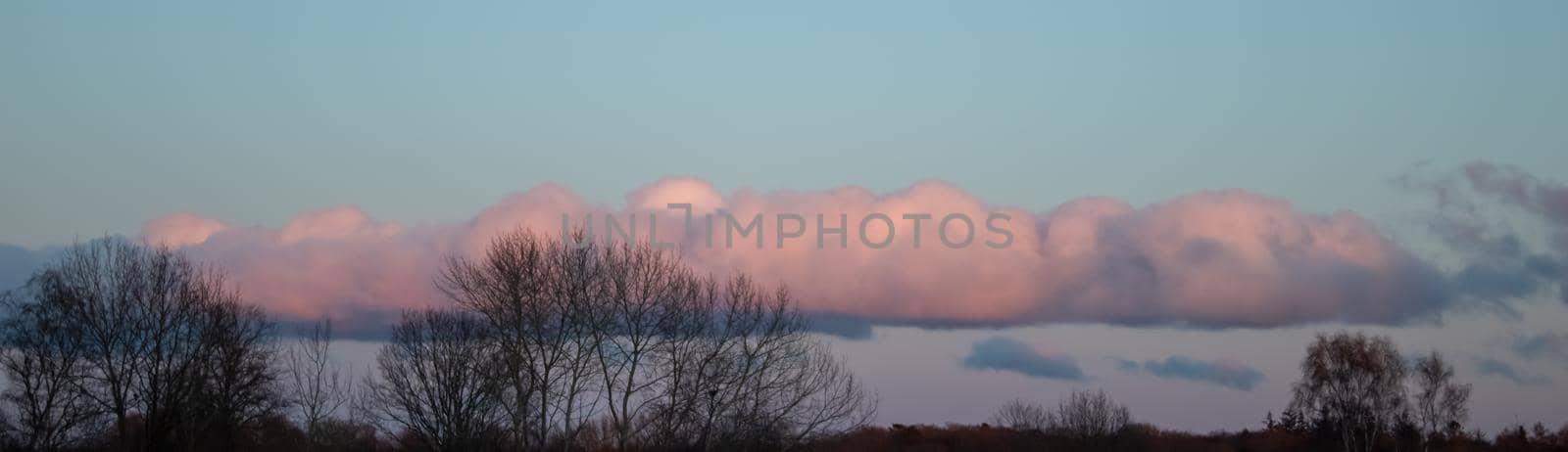 Beautiful panorama of orange and yellow clouds at sunrise and sunset in a blue sky