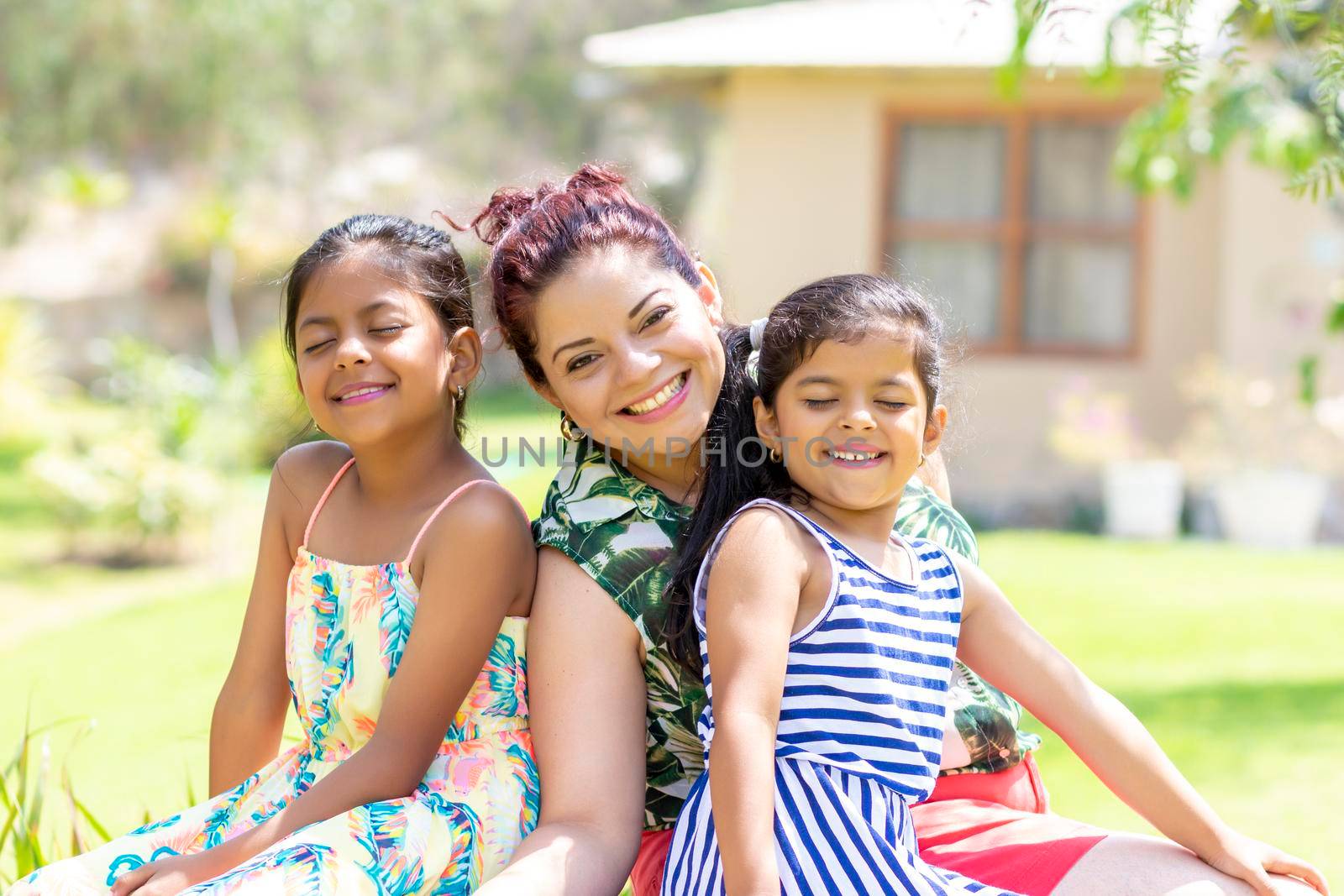 Love between a young mother and her two pretty daughters outdoors