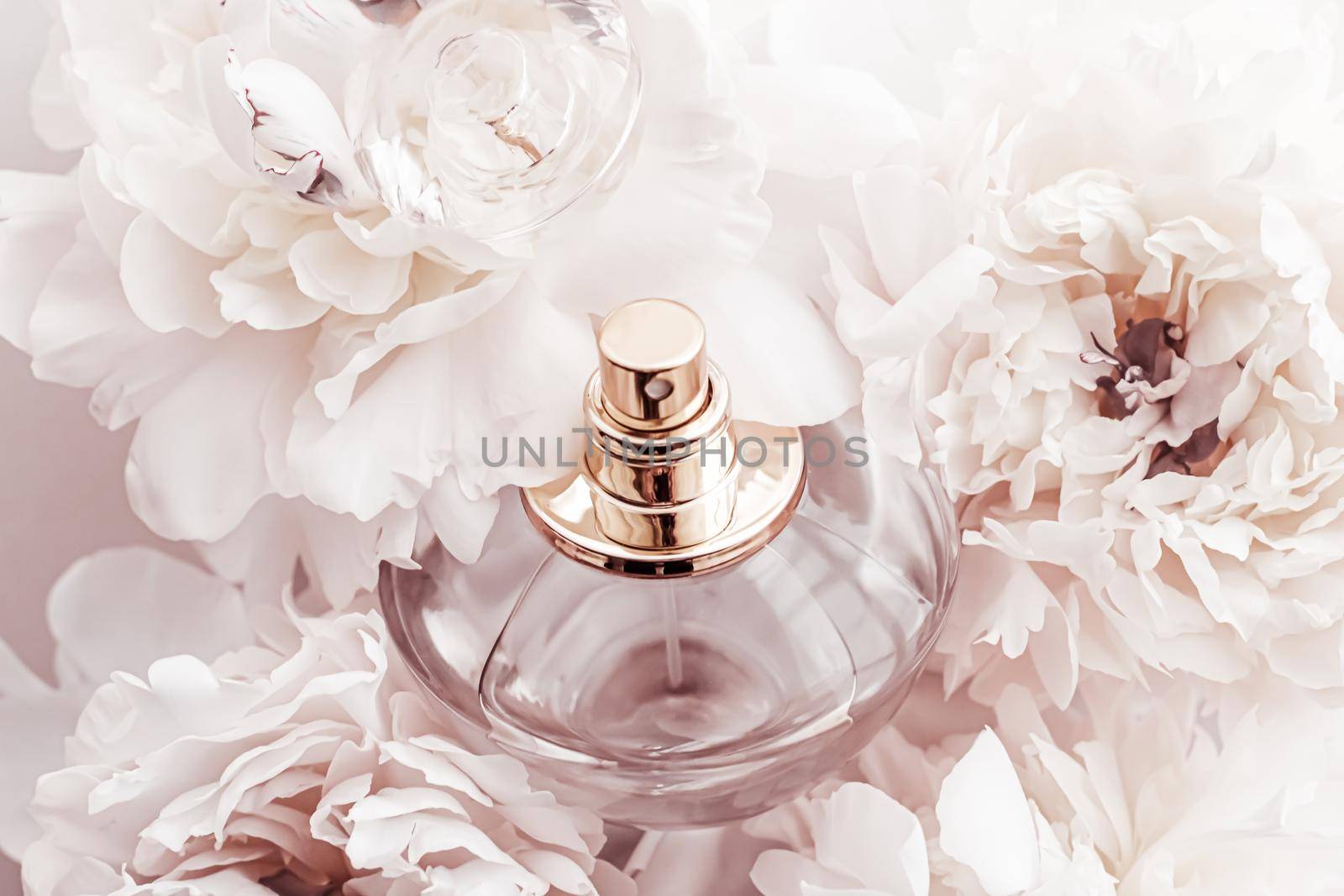Fragrance bottle as luxury perfume product on background of peony flowers, parfum ad and beauty branding design