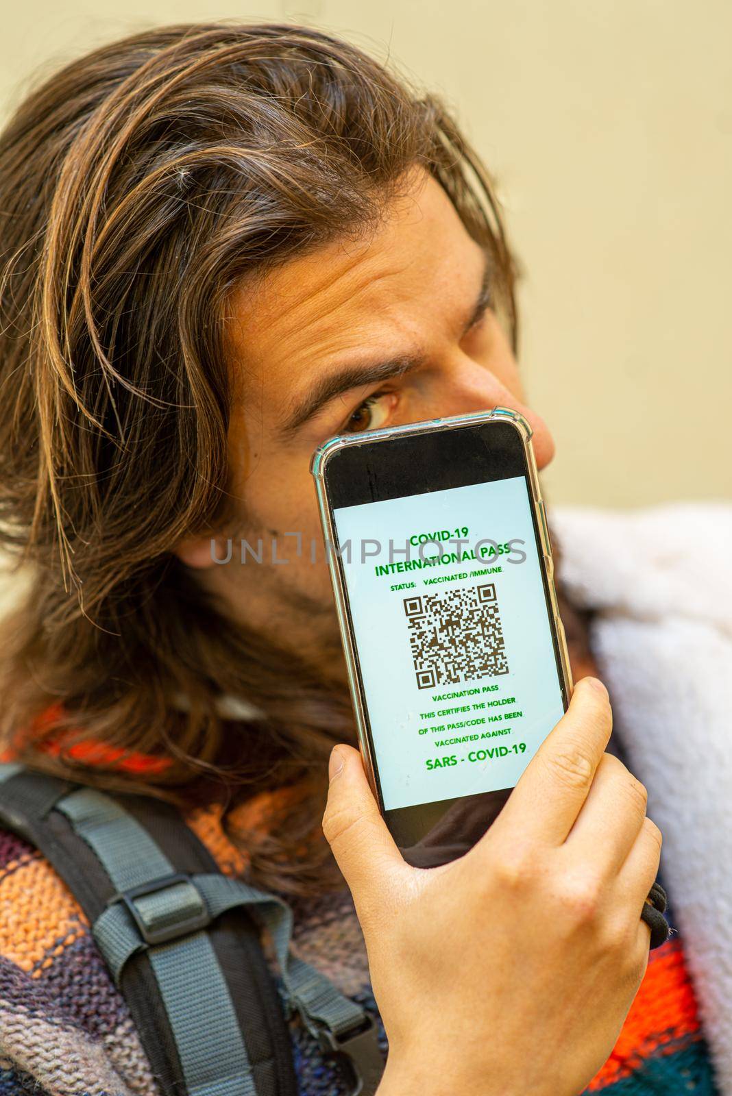 young person holding a spartphone showing the coronavirus immunity certificate