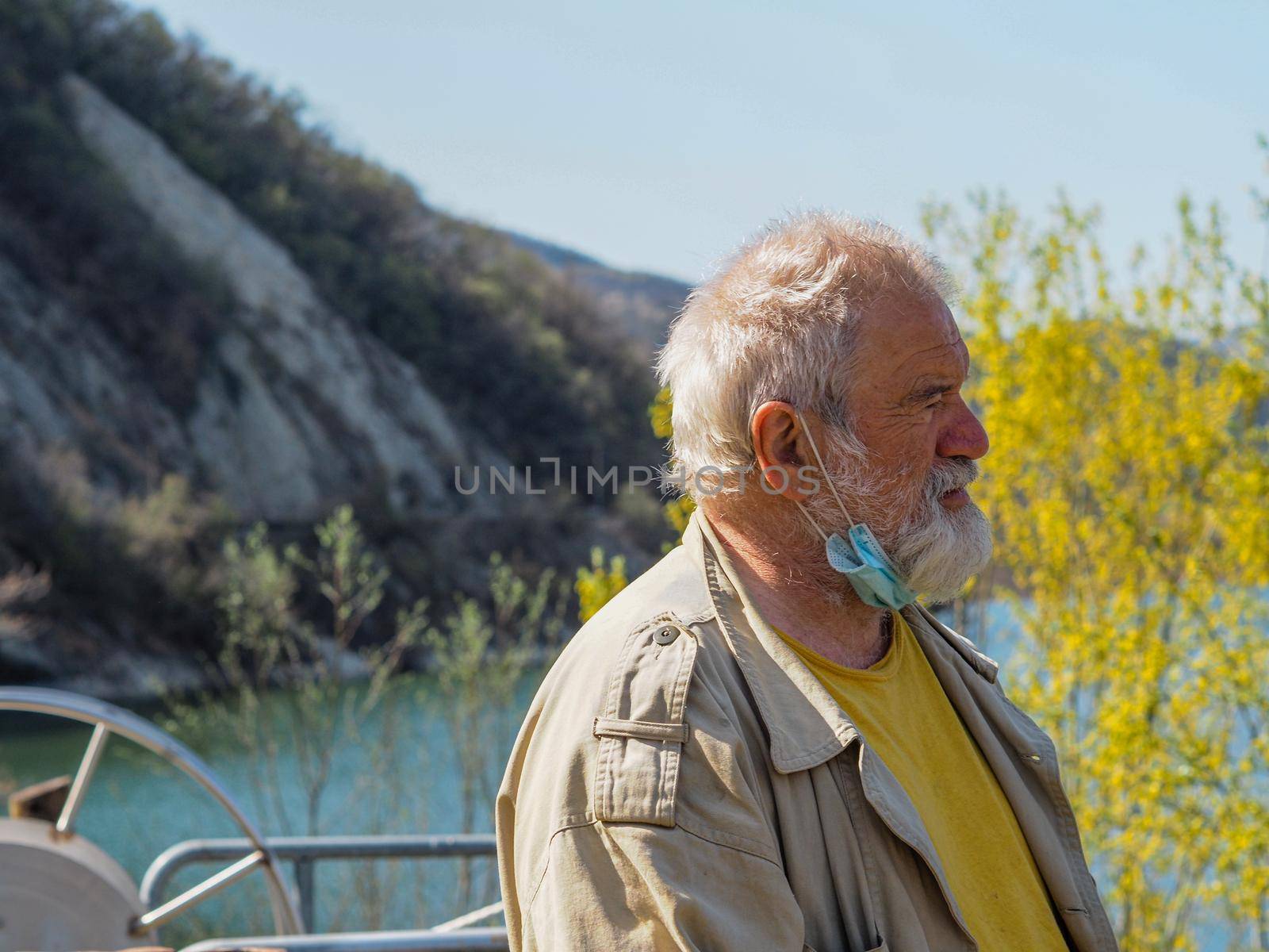 portrait of an active senior adult man at the lake breathing and relaxing outdoors