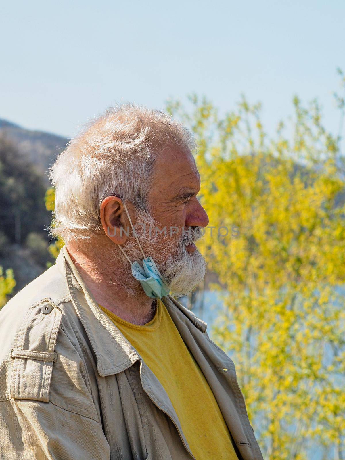 portrait of an active senior adult man at the lake breathing and relaxing outdoors