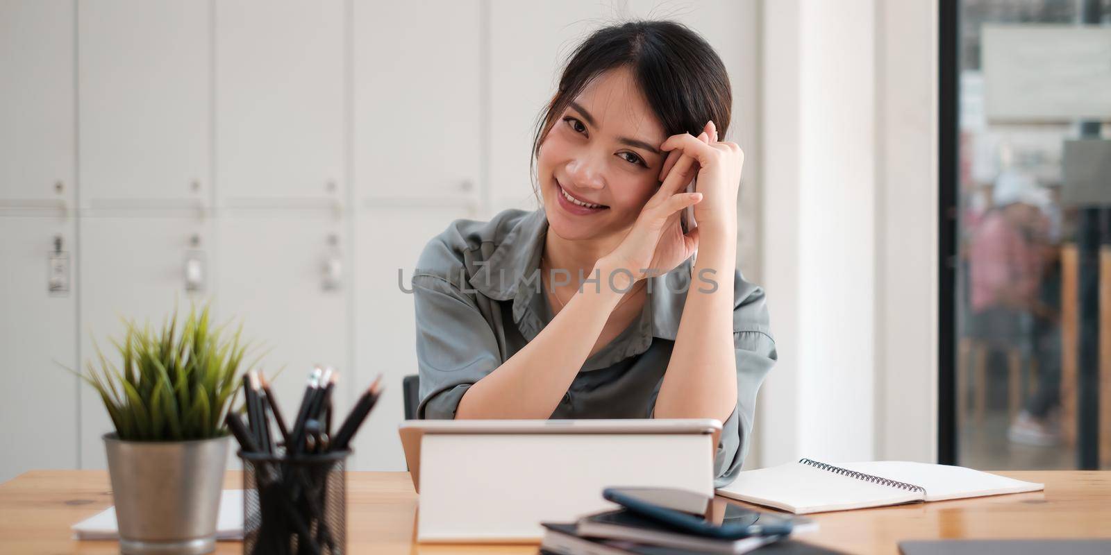 Joyful businesswoman sitting at desk looking at laptop screen talking with friend make informal video call