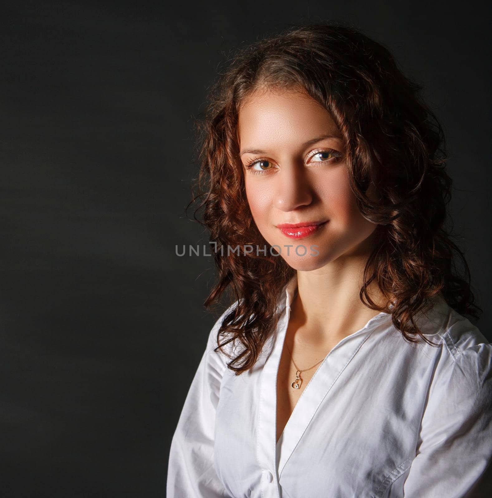 portrait of a young brunette girl in the studio on black background