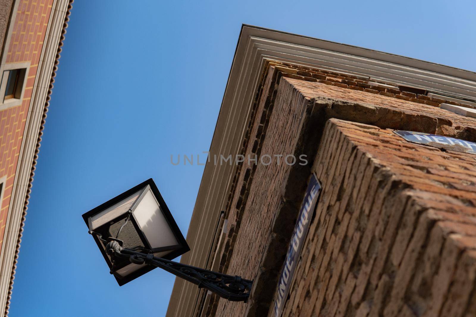 Corner of an old building seen up close and from below with a blue sky.