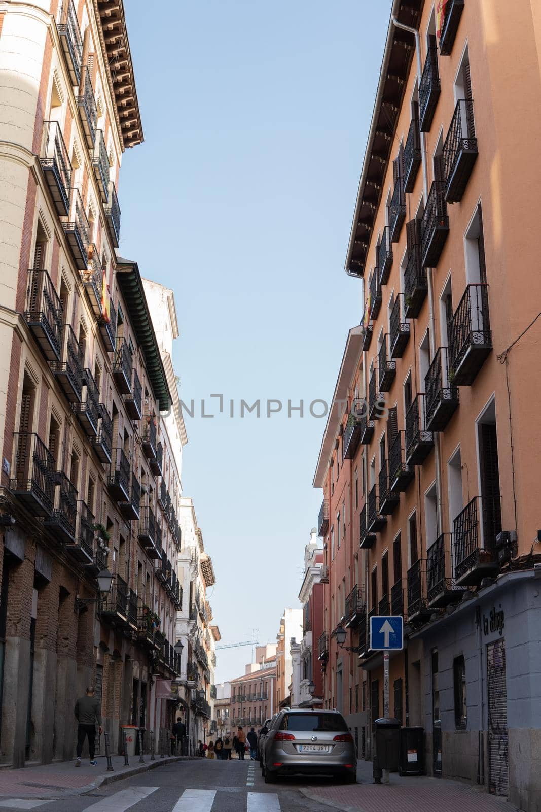 Straight street in madrid surrounded by old and beautiful buildings