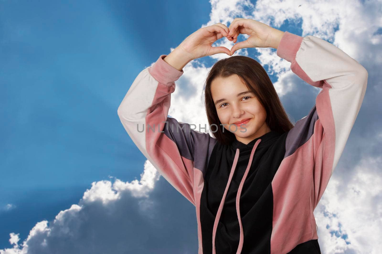 portrait of teenage brunette girl posing in studio on cloudy background