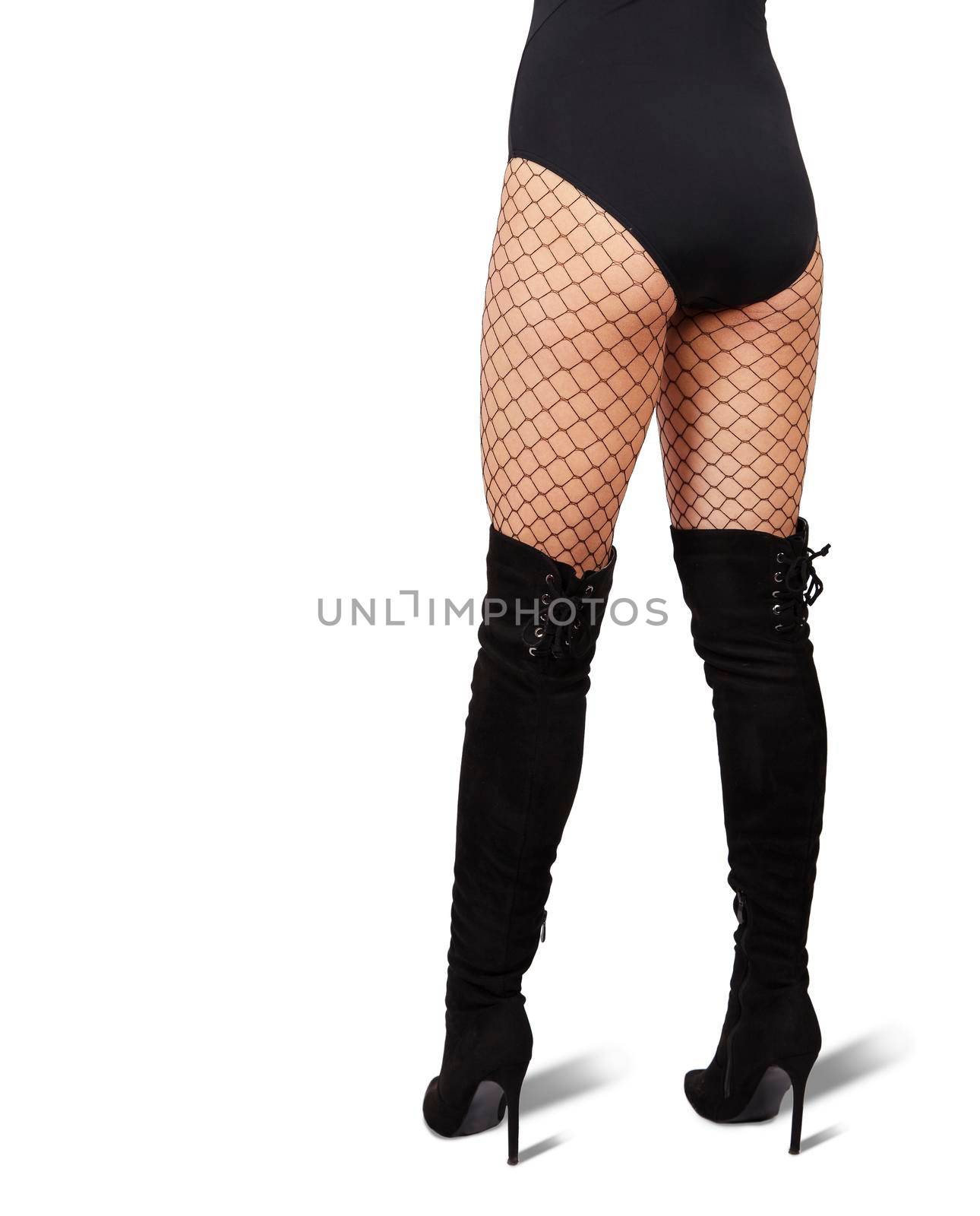 slender female legs in mesh tights and black boots on white background. back view