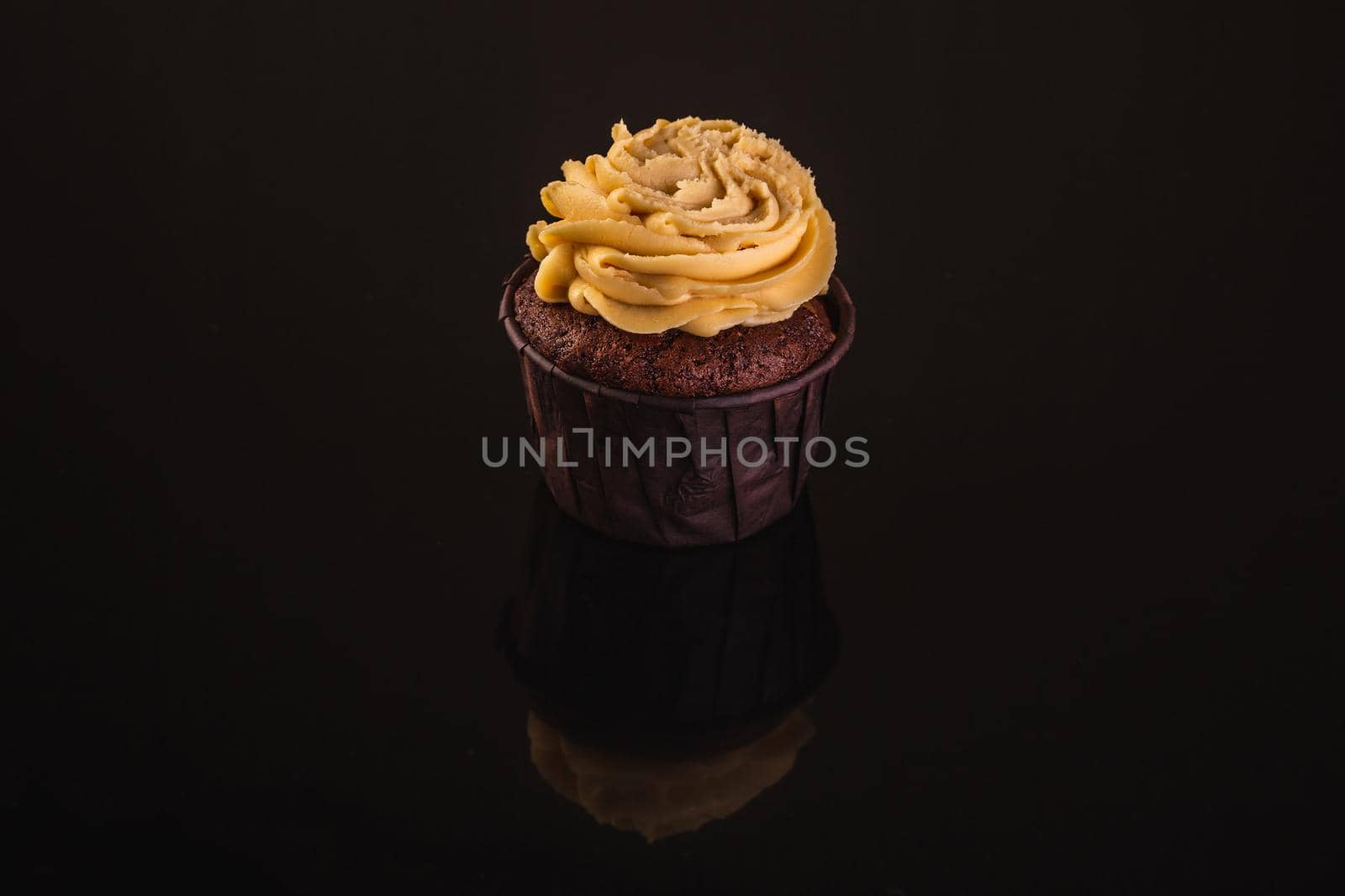 Peanut Butter Cupcake On A Black Background With Reflection.