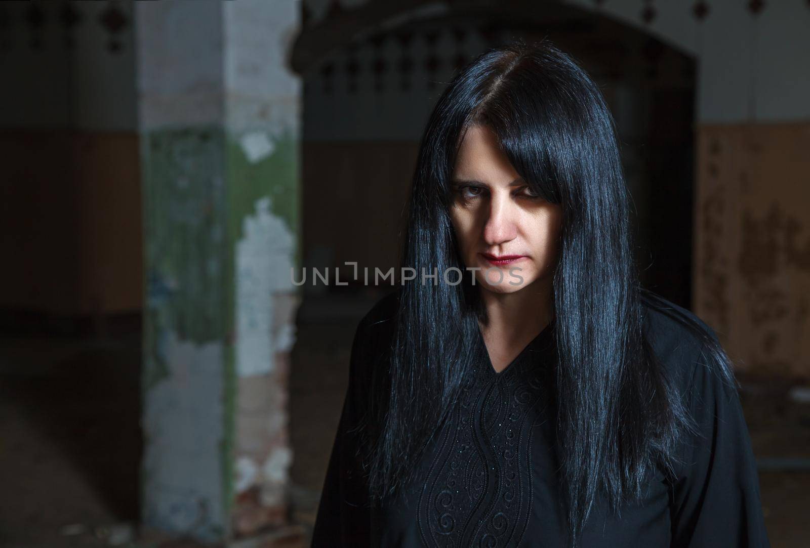 portrait of young goth woman in an abandoned building. indoor closeup