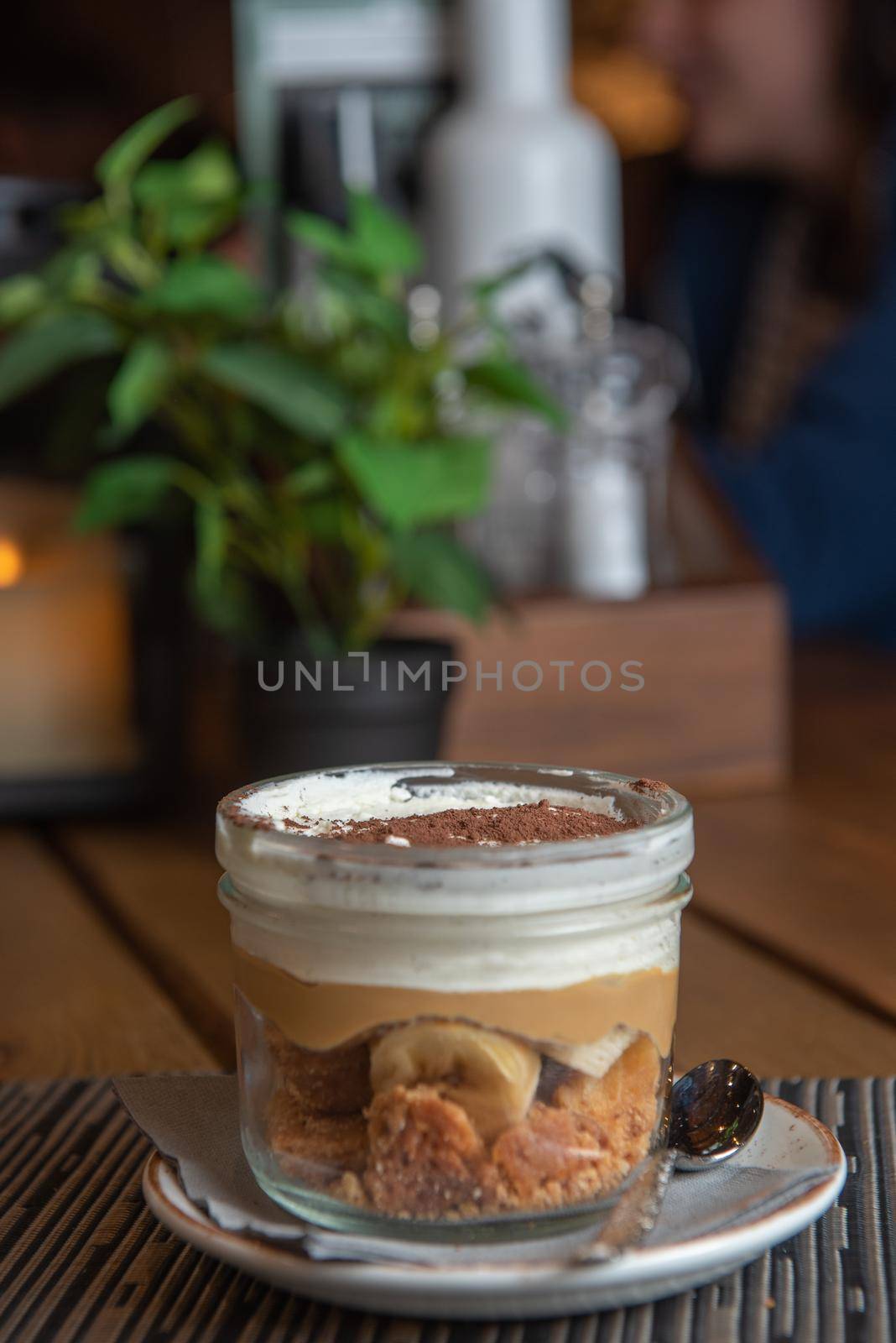 Tiramisu with banana in transparent glass.