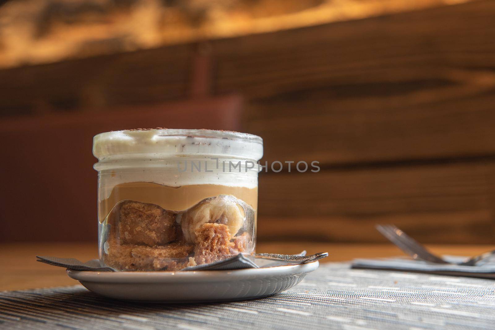 Tiramisu with banana in transparent glass.